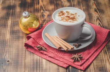 Eggnog. Tarçın çubuklu geleneksel Noel kokteyli ve kırmızı peçete ve ahşap masa anason..