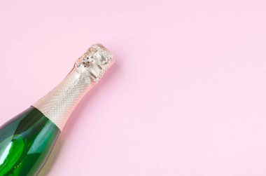 Şampanya kadehleri ve pembe arka planda şişe, mesaj için yer.