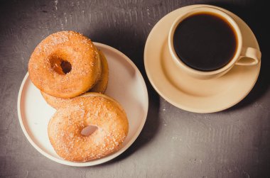 Tabakta çörek ve bir fincan sade kahve. Üst Manzara. Koyu