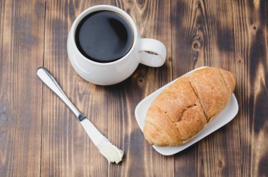 Fransız kahvaltısı. Sütlü kahve ve kruvasanla birlikte beyaz bardak.