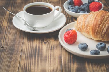 Bir fincan kahveyle nefis kahvaltı ve taze kruvasan. 