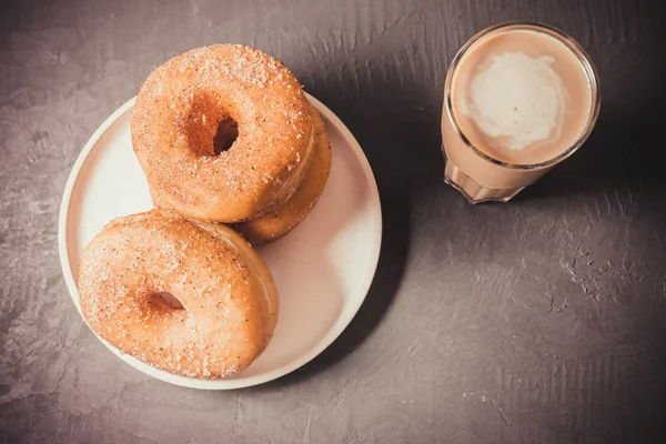 咖啡加牛奶和甜甜圈在黑暗的桌子上 顶部视图。 新鲜 — 图库照片