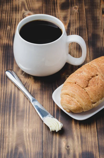 Pequeno-almoço francês. Caneca branca com café preto e croissant com — Fotografia de Stock