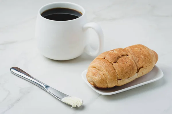 Французский завтрак. Белая кружка с черным кофе и круассан с — стоковое фото