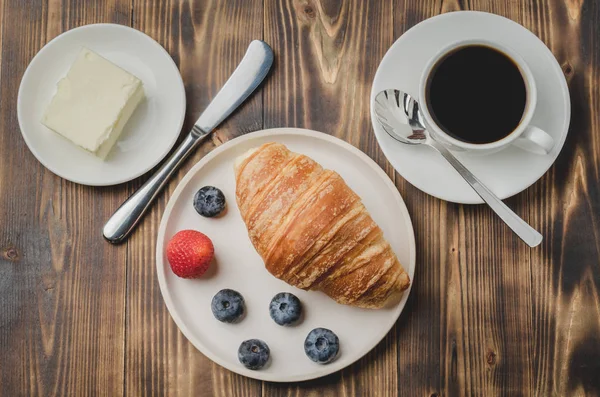 Tasse à café, croissant aux baies dans un bol blanc et couteau à beurre — Photo