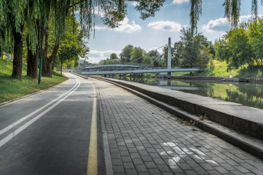 Parktaki bisiklet yolu nehir boyunca yeşil güzel ağaçlarla dolu.