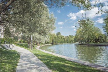 Nehir kenarındaki parkta yürüyüş yolu. Güzel bir yaz manzarası