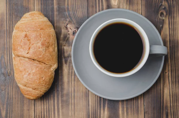 Descanso. Taza gris con café negro y croissant en w oscuro — Foto de Stock