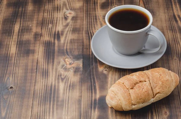 Pausa para café. Xícara cinza com café preto e croissant no escuro w — Fotografia de Stock