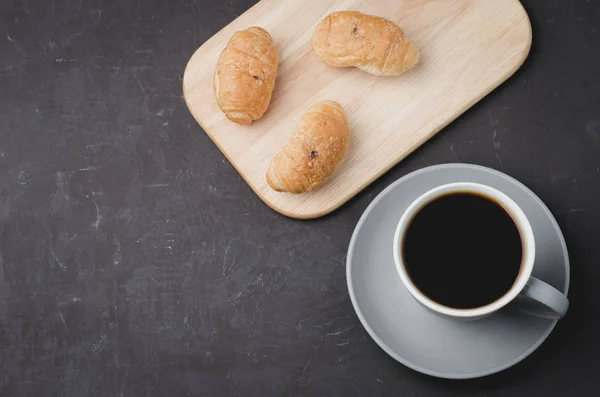 Taza gris con café negro y bandeja de madera con croissants en da — Foto de Stock