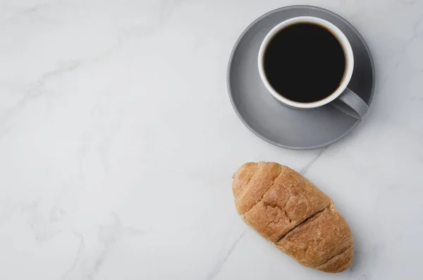 Istirahat kopi. Gelas abu-abu dengan kopi hitam dan croissant pada putih — Stok Foto