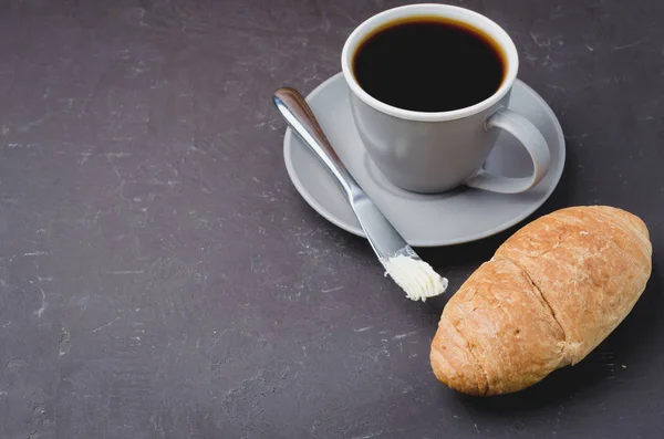 Pausa para café con croissant, cuchillo de mantequilla y taza de café negro — Foto de Stock