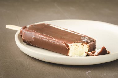 Dondurma. Çikolata jöleli dondurma. Çubukta beyaz bir teknede.