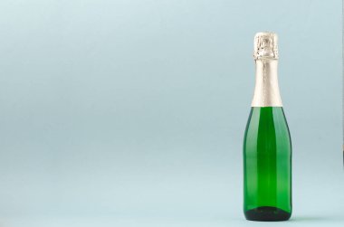 Mavi arka planda şampanya bardakları ve şişe, mesaj için yer.