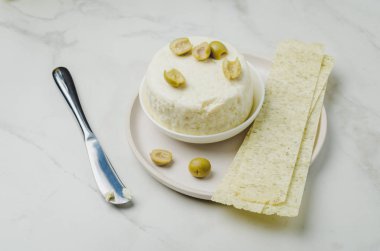 Zeytinli krem peynir, kasede uzun patates kızartması ve bıçakla...