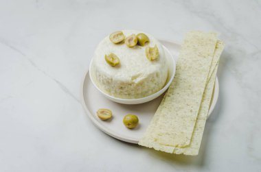 Zeytinli krem peynir ve mermer bir kase içinde uzun patates kızartması.