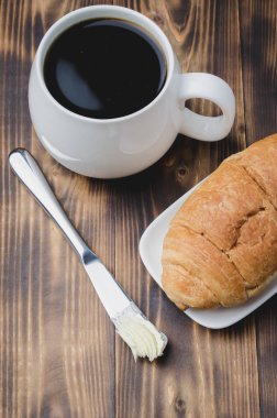 Fransız kahvaltısı. Sütlü kahve ve kruvasanla birlikte beyaz bardak.