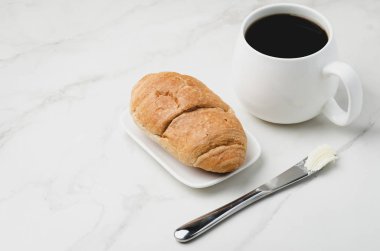 Fransız kahvaltısı. Sütlü kahve ve kruvasanla birlikte beyaz bardak.