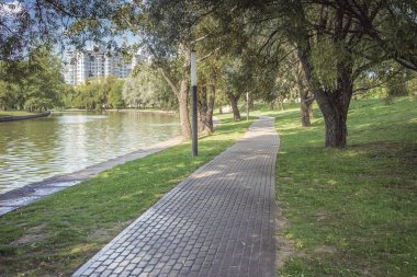 Nehir kenarındaki parkta yürüyüş yolu. Güzel bir yaz manzarası