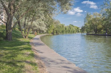 Şehir parkındaki nehir. Yazın güzel manzarası. Ağaçlar selam