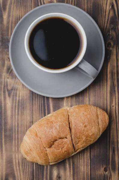 Pausa para café. Xícara cinza com café preto e croissant no escuro w — Fotografia de Stock
