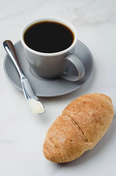 Pausa para café com croissant, faca de manteiga e xícara de café preto — Fotografia de Stock