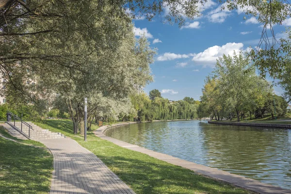 Nehir kenarındaki parkta yürüyüş yolu. Güzel bir yaz manzarası