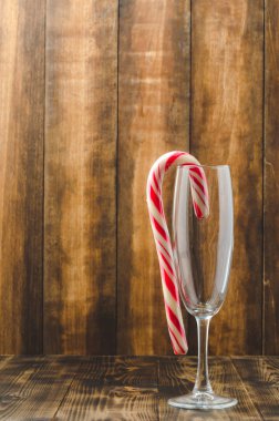 Ahşap arka planda boş bir bardakta Noel şekeri. Kopyala