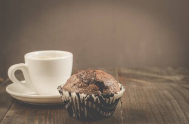 Kahve fincanı, çikolatalı kek, kahve fincanı ve siyah ahşap bir masada çikolatalı kek. Boşluğu kopyala
