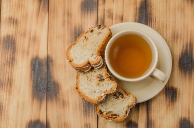 Çay fincanı ve hamur işleri ahşap masada. Kahvaltıda. Tetikleyiciniz için telif alanı ile en üstteki görünüm