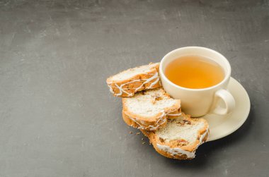 Çay fincanı ve pastalar koyu taş masanın üzerinde. Seçici odak ve metin boşluğu