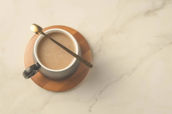Mug Hitam Cappuccino Dengan Sendok Dalam Dukungan Kayu Atas Meja — Stok Foto