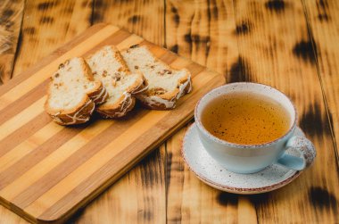Çay fincanı ve masada dilimlenmiş hamur işleriyle kahvaltı. Seçici odak