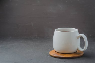 Siyah taş bir masanın üzerinde bambu destekli beyaz bardak, kopyalanmış uzay.