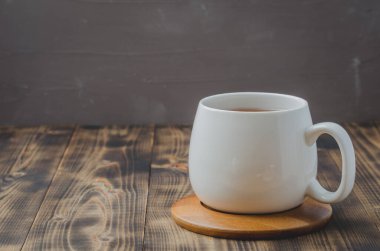 Tahta bir masada bambu destekli beyaz bardak, seçici odak, kopyalanma alanı