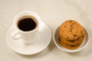 kahve fincanı ve kurabiyeler / kahvaltı beyaz kahve fincanı ve mermer arka planda kurabiyeler, seçici odaklanma. Üst görünüm