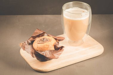 Çikolata dolgulu kek ve ahşap tepside kapuçino bardağı. Çikolata dolgulu kek. Ve kapuçino bardağı..