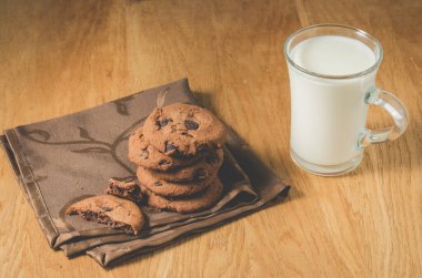 Çikolatalı kurabiye ve bir bardak süt / çikolatalı kurabiye ve bir bardak süt ahşap arka plan. Seçici odak