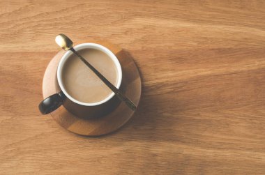 Ahşap destekli bir kapuçino kapuçinosu, ahşap bir masa, üst görünüm ve kopyalama alanı