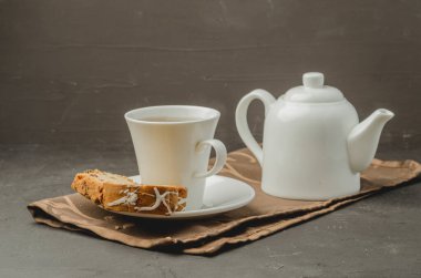 Beyaz çay fincanı ve üzerinde hamur işleri olan çaydanlık. Kahvaltı..