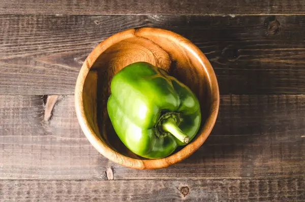 木制碗上的绿色红辣椒 深色背景上的木制碗上的绿色红辣椒 顶部视图 — 图库照片