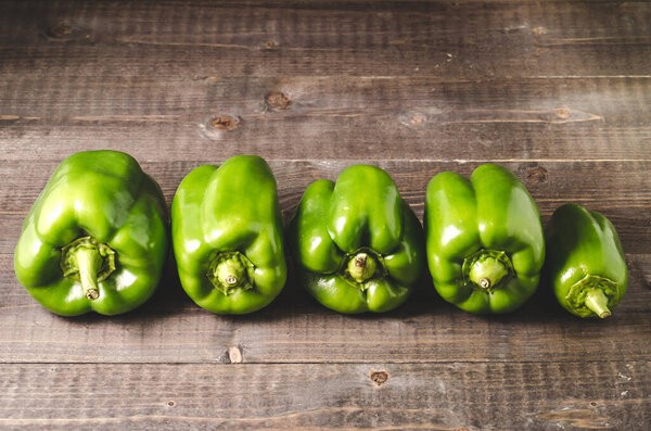 зеленый перец паприка на деревянном фоне / свежий зеленый перец паприка на деревянном фоне. Селективный фокус
