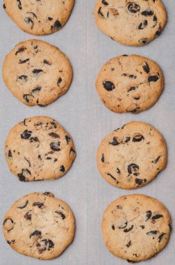 Pişirme kağıdında çikolatalı çerezler. Kurabiyeler ve çikolatalar kabartma kağıdında. Taze hamur işleri. Üst görünüm.