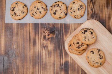 Tahta bir masada çikolatalı kurabiyeler. Taze hamur işleri / Çikolatalı kurabiyeler ahşap bir masada. Taze pastalar. Üst görünüm ve boşluk kopyala.