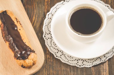 Kahve fincanı ve kahve fincanı ile kahvaltı ve ahşap bir masanın üzerinde ekkin. Üst görünüm