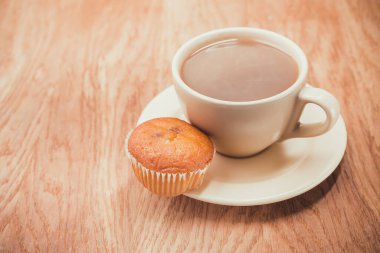 Kahveli kek, ahşap desenli masa. Kahve molası