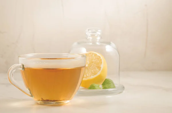 tea with a lemon and mint in glass cup/tea with a lemon and mint in glass cup on a white background, selective focus