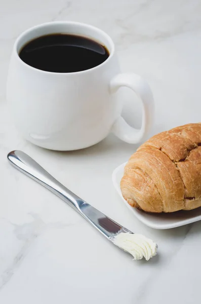 法国早餐 白杯子加黑咖啡 羊角面包加黄油刀放在白石桌上 咖啡休息时间 — 图库照片