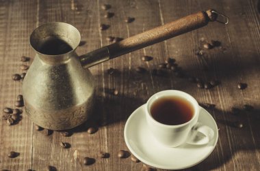 Bakır demlik, sıcak kahve fincanı, bakır demlik ve ahşap bir arka planda sıcak kahve fincanı. Üst görünüm