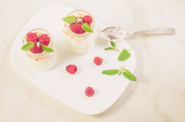 Beyaz tepside ahududu ve nane aromalı yoğurt.